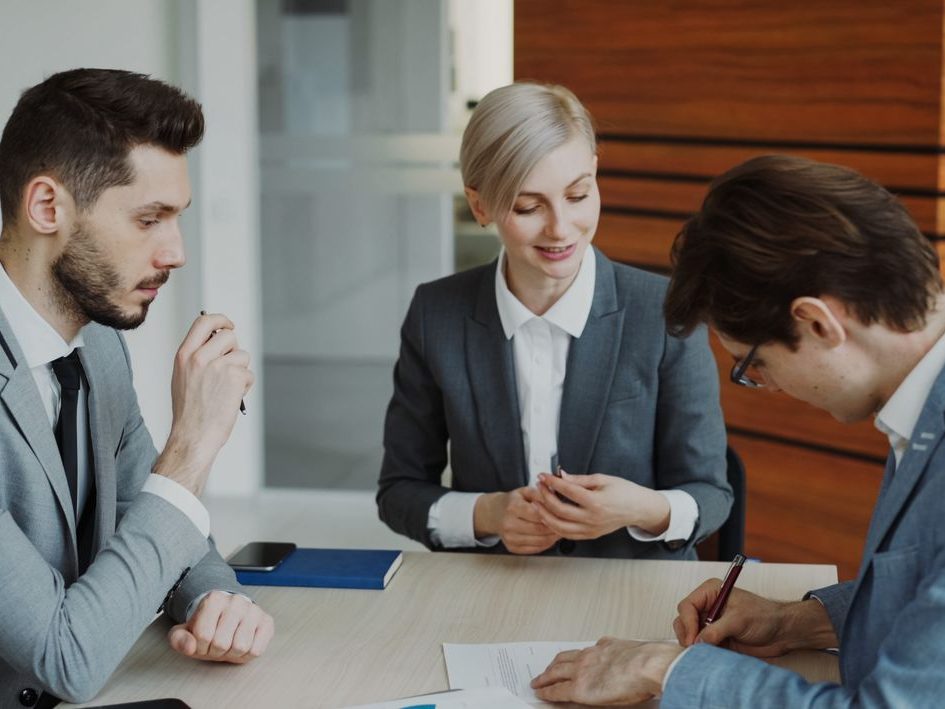 Two financial advisors meeting with a client at a Davis office table